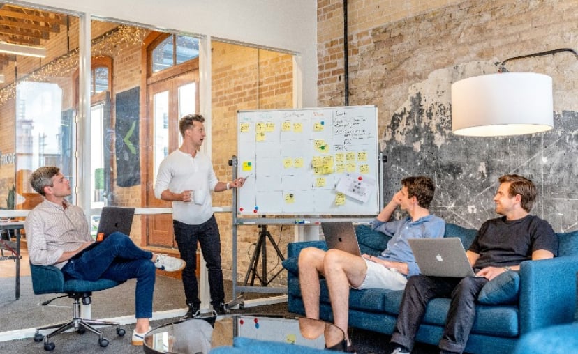 Digital marketing team planning a social media growth strategy at a whiteboard